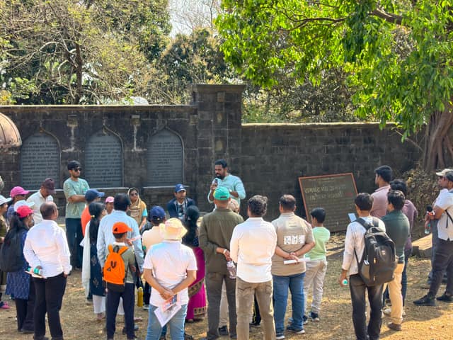 पन्हाळा हेरिटेज वॉकमध्ये जुन्या दगडी भिंतीजवळ जमलेले सहभागी